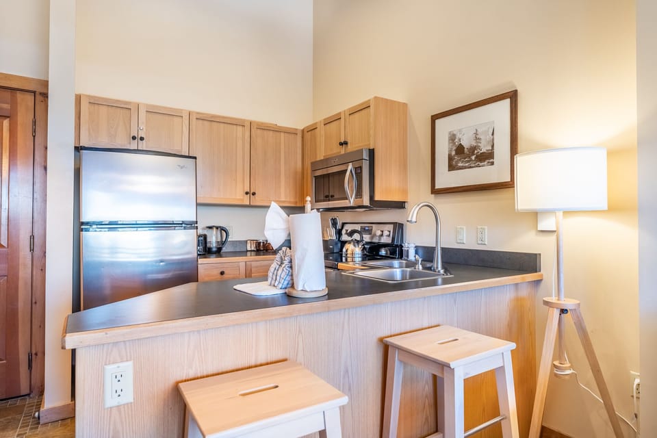 Your fully equipped kitchen features stainless steel appliances and warm wood cabinetry, perfect for preparing meals during your stay.