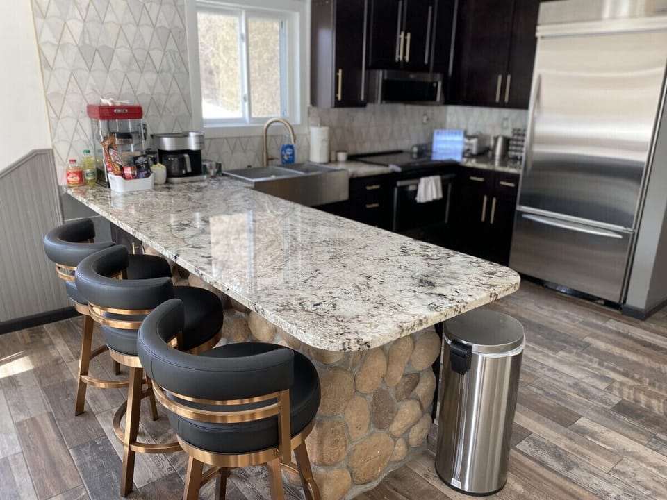 Chef's kitchen with stainless appliances and bronze stools