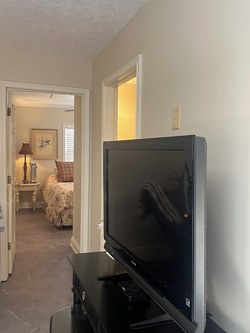 View from main living area into bedroom one. Also showing TV.