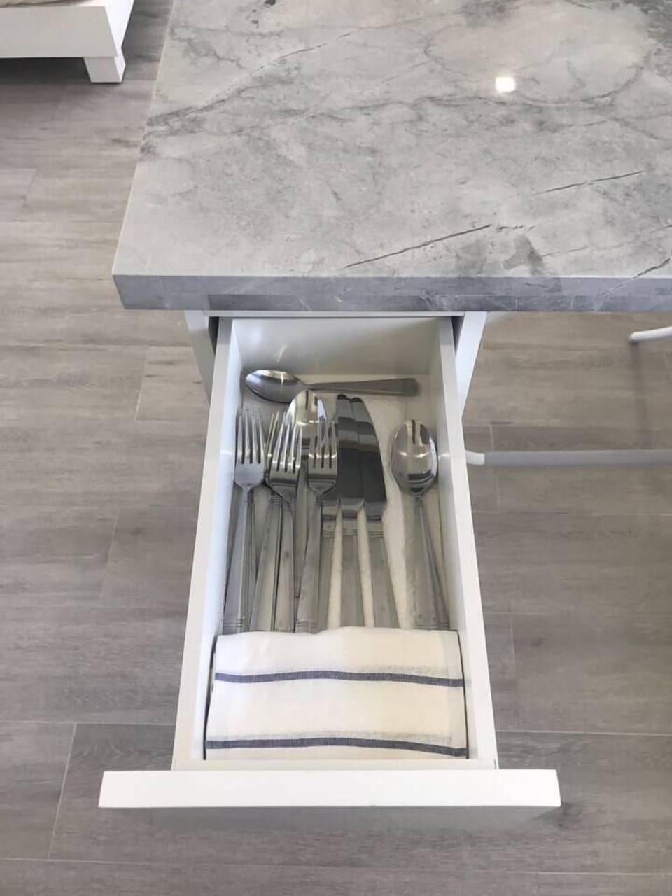 Ready to Dine: Fully stocked cutlery drawer. Every detail matters, down to the perfectly organized drawer and kitchen cabinets, ensuring you have everything you need for a home-cooked meal.