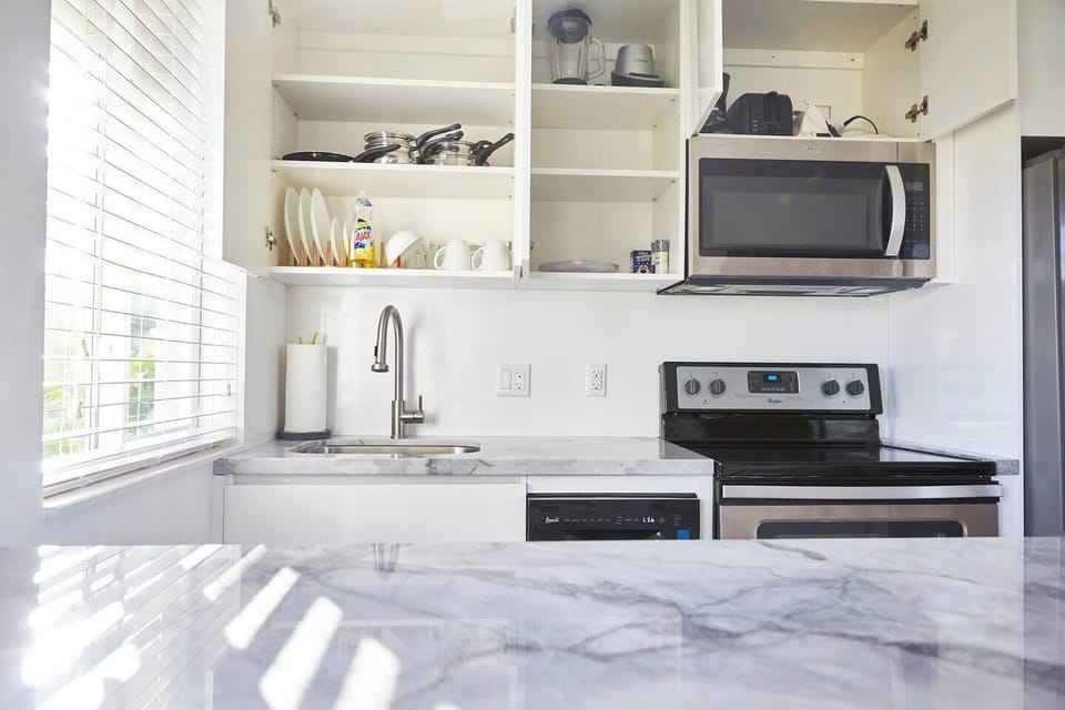 fully stocked with dishes, silverware, cooking utensils, pots & pans, coffee maker, toaster, blender.