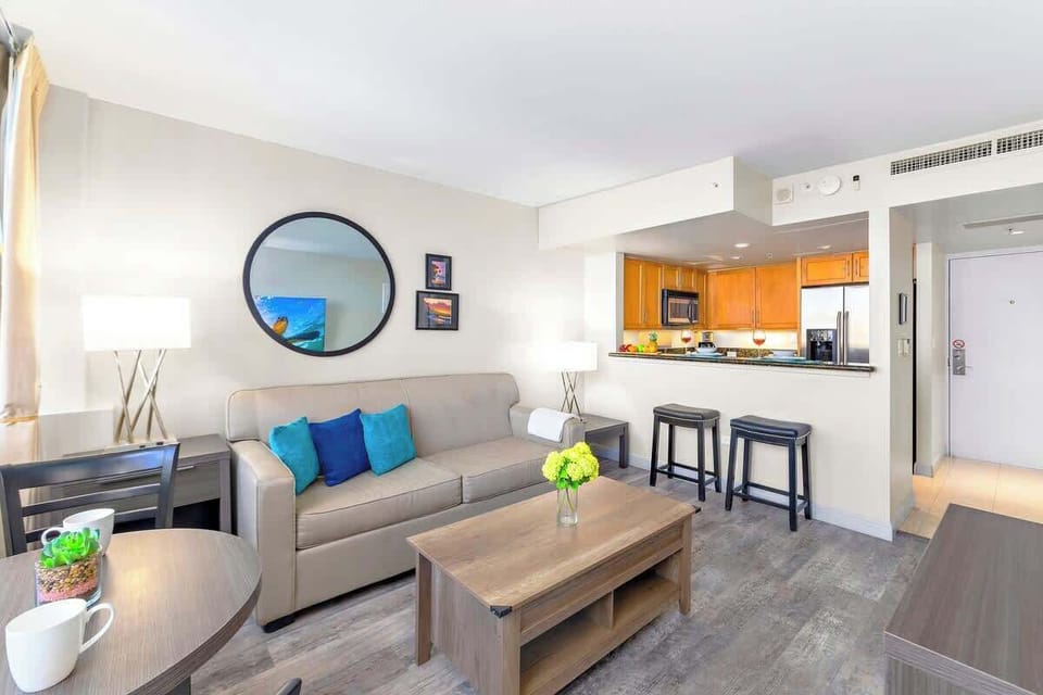 Living room with dining table for up to two people and countertop with 2 bar stools