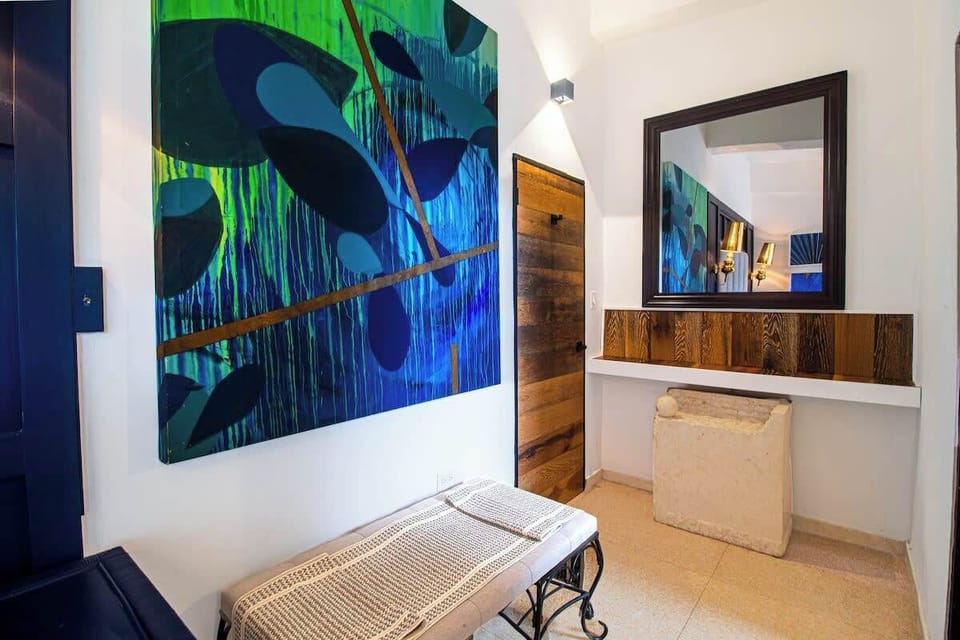With its striking blue decor, gold accents, and contemporary artwork, this bedroom exudes style and comfort, perfectly marrying modern design with a cozy atmosphere.