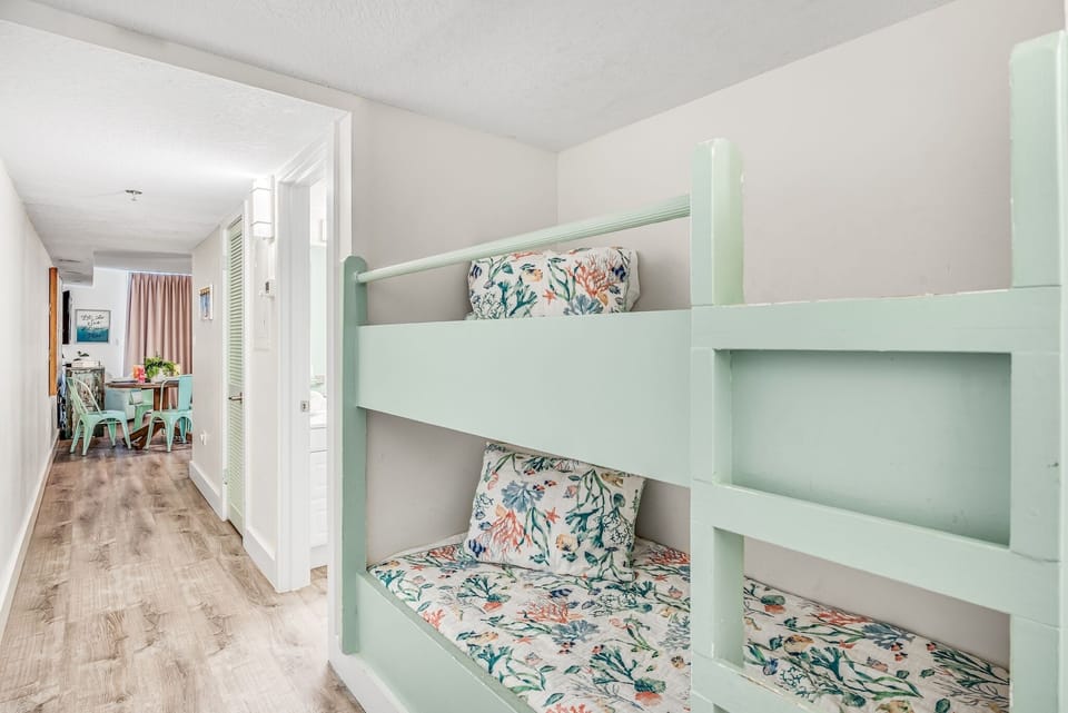 Sleep soundly in your charming mint-green bunk bed, complete with floral linens and cozy reading nook below.