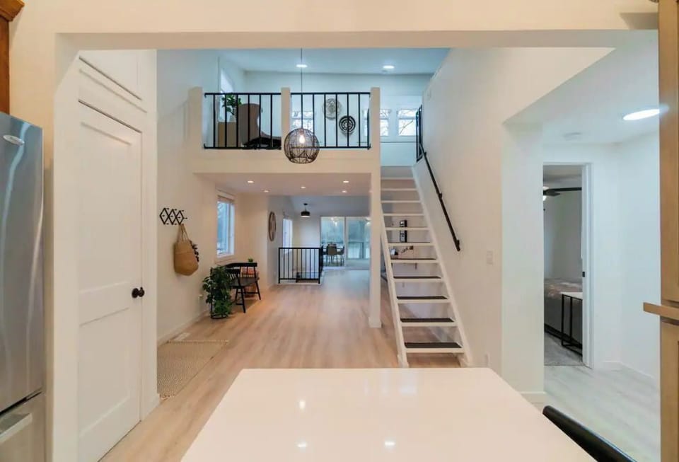View from the kitchen to the main living area, bedroom hallway, and loft space