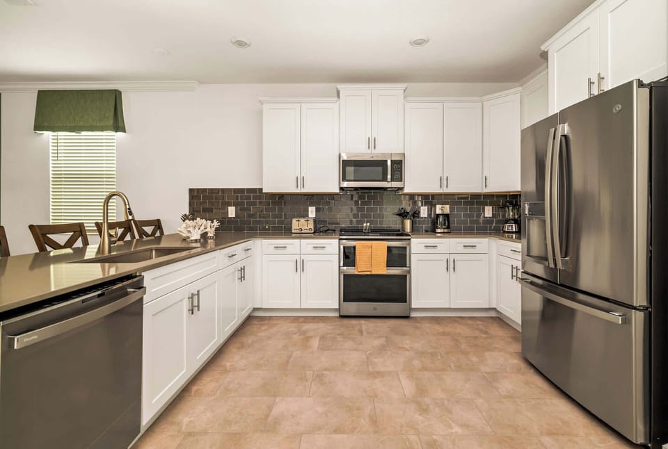 Modern kitchen with sleek appliances and ample seating, perfect for hosting family meals and gatherings.