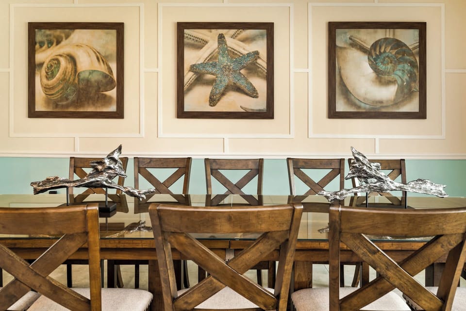 Elegant dining room with coastal-themed art, perfect for hosting memorable meals.