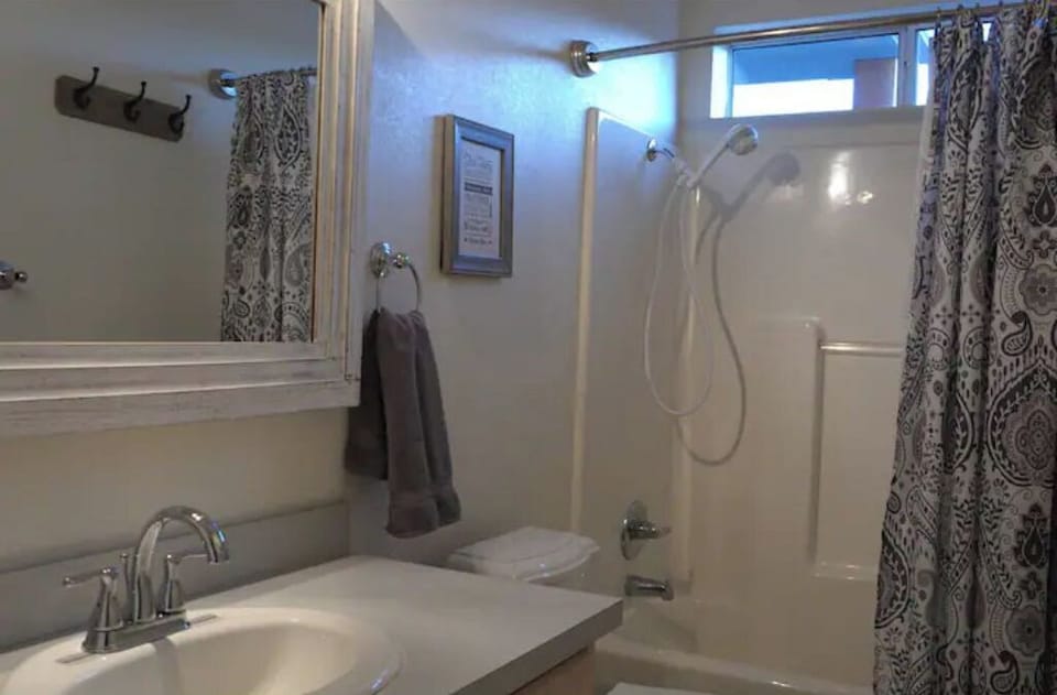 Full bathroom across from queen bed and bunk bed rooms
