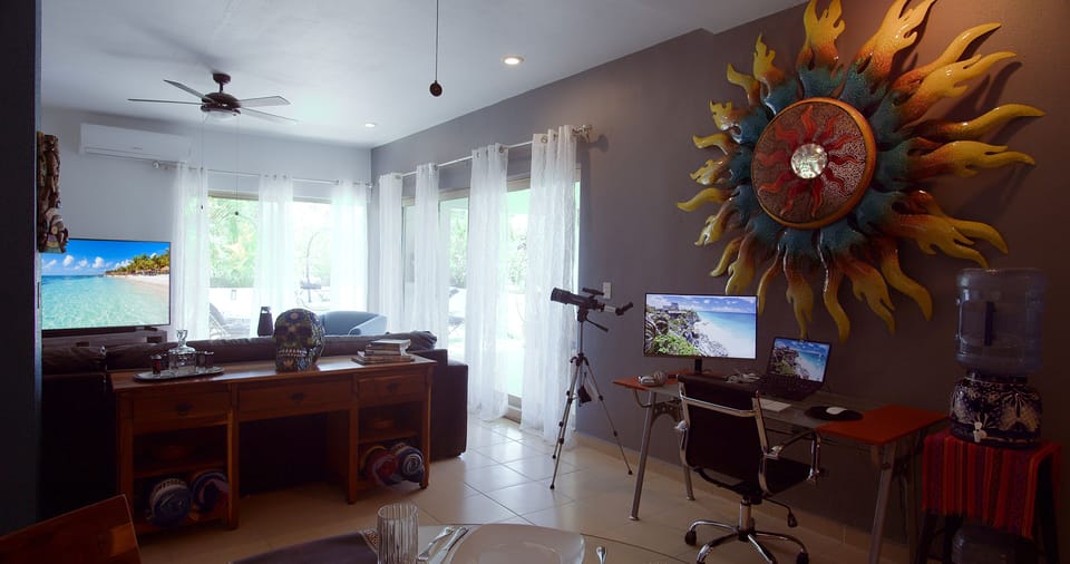 Work space has desk, chair, 27" curved monitor, laptop stand & mouse/keyboard.