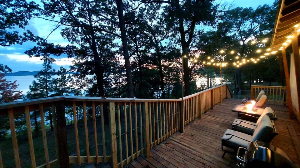Back deck with string lights, fire pit, and propane grill