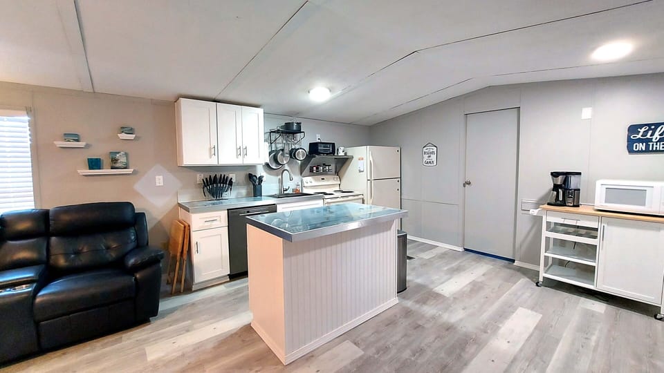 Kitchen with porcelain tops, refrigerator, range, toaster, microwave, coffee bar