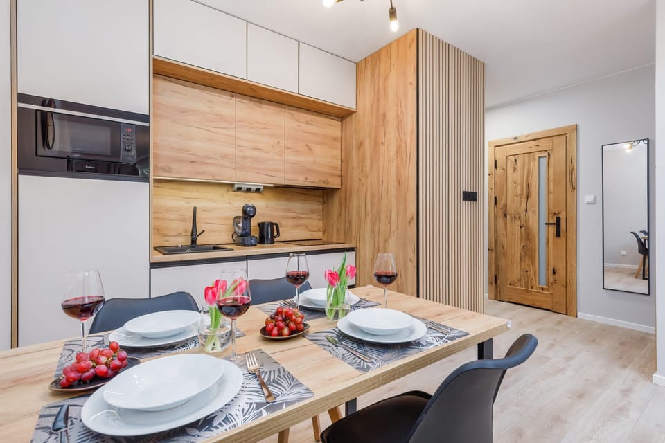 A dining table set for a meal in a kitchen with wooden accents.
