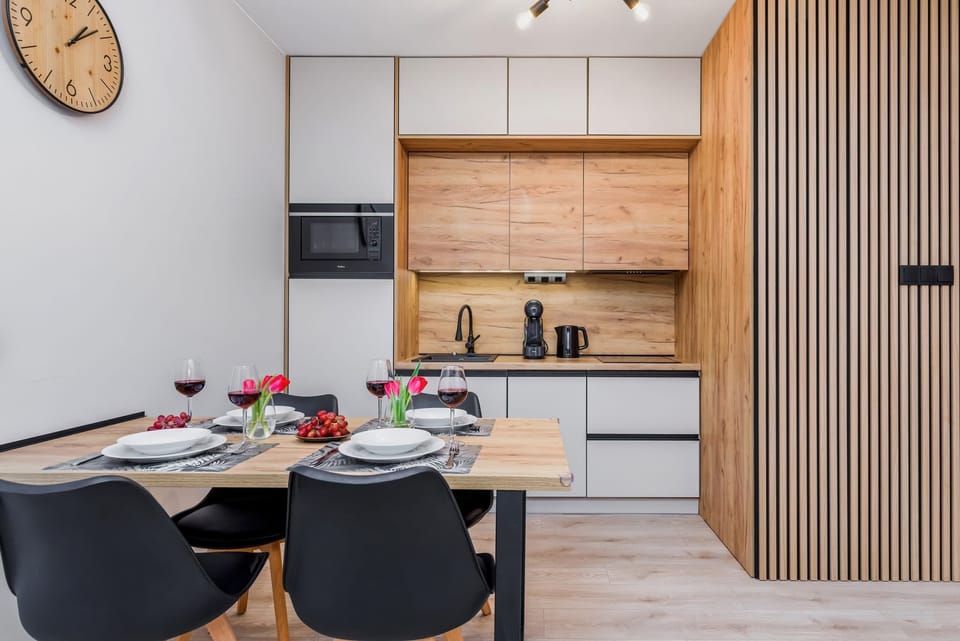 A kitchen with modern design elements and a dining table for four.
