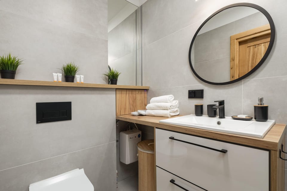 Another view of a contemporary bathroom with stylish decor and small potted plants.
