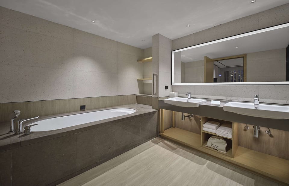 Deluxe Suite, 1 King Bed | Bathroom | Designer toiletries, hair dryer, slippers, towels