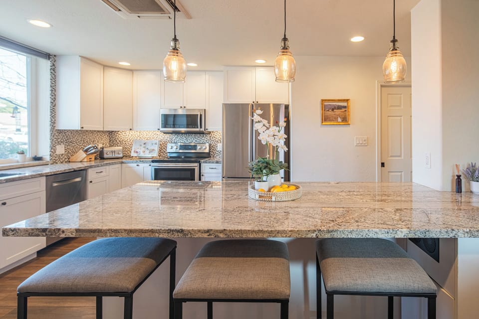 Large Island with 3 Bar Stools. There are 2 kitchens with islands in the home.
