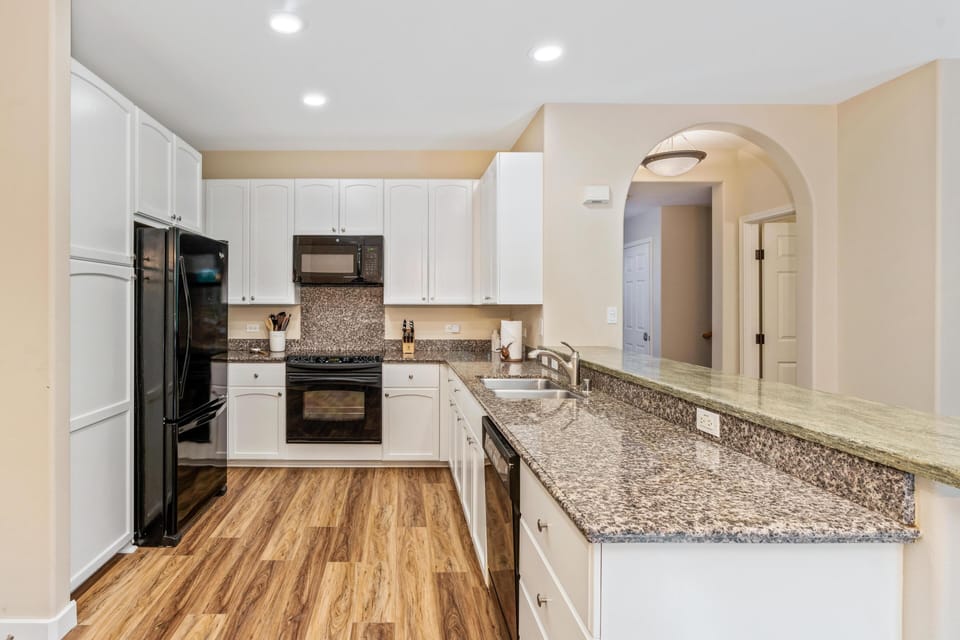 Full kitchen with breakfast bar, granite counters, and modern appliances