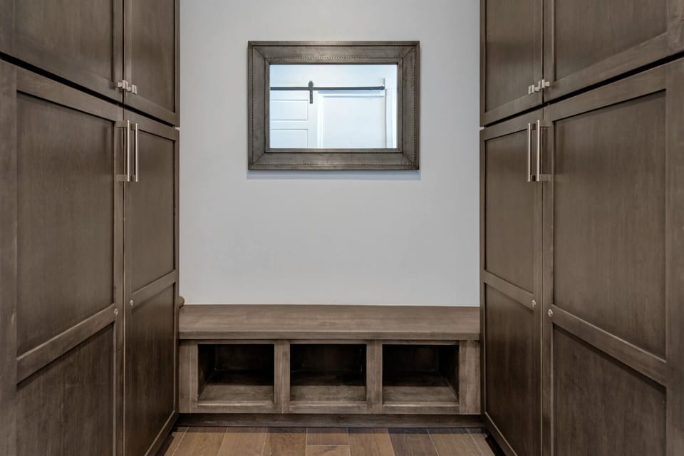 Your entryway welcomes you with warm wood cabinetry and thoughtful storage cubbies—perfect for keeping your essentials organized while maintaining a polished, inviting space.
