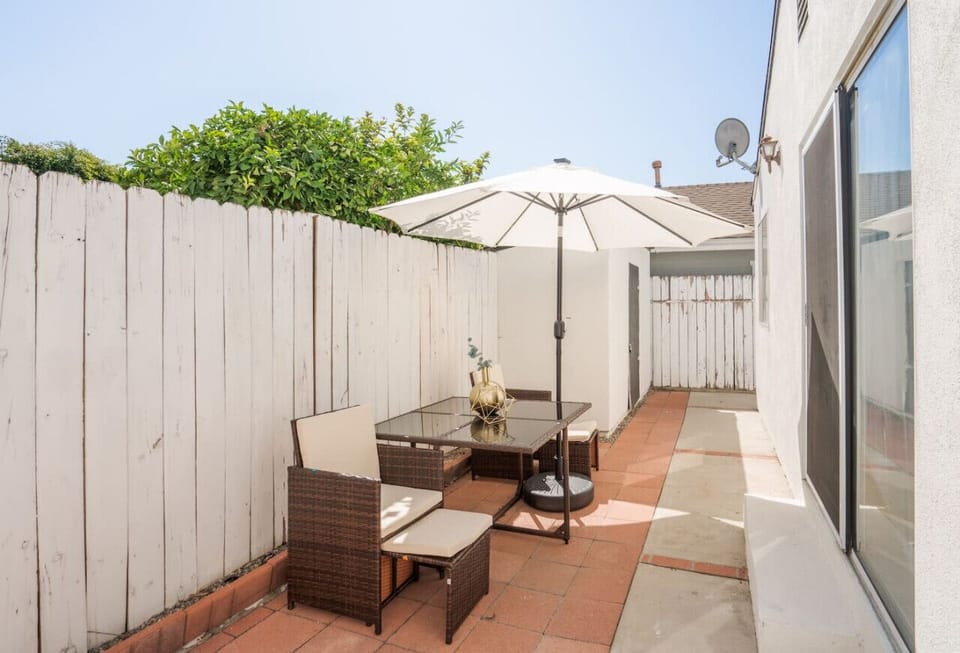 Cute backyard with dining area and an umbrella.