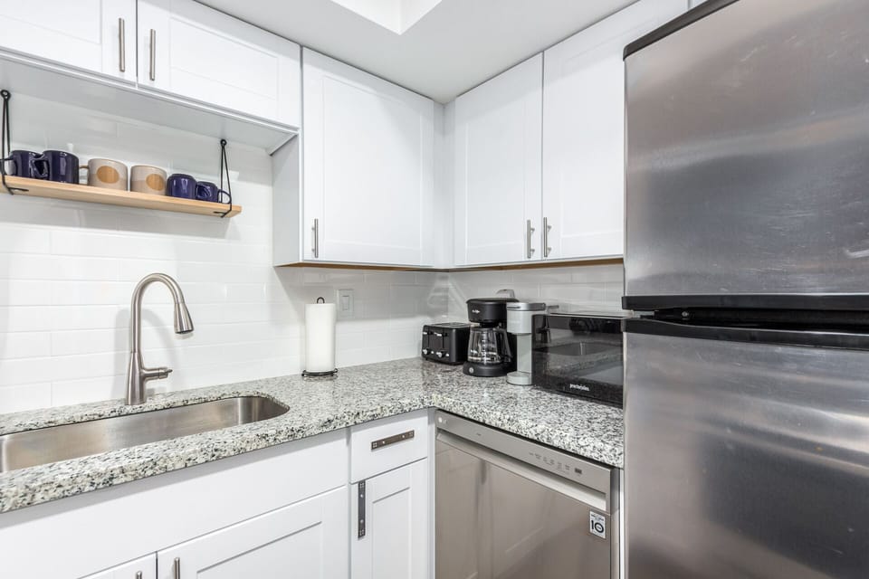Kitchen features granite counters, new cabinets, Keurig and Mr Coffee pots.