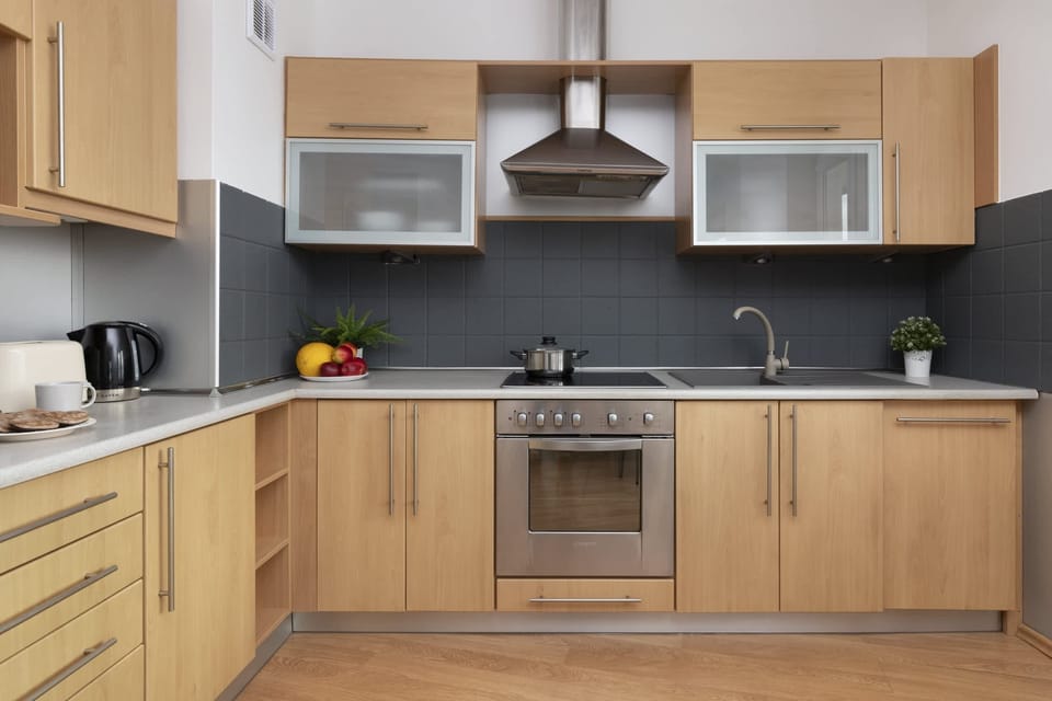 A fully equipped kitchen with wooden cabinets and stainless-steel appliances.
