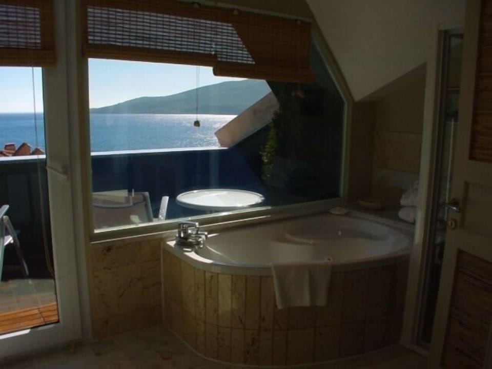 King Suite with Whirlpool | Bathroom | Deep soaking tub, rainfall showerhead, hair dryer, slippers