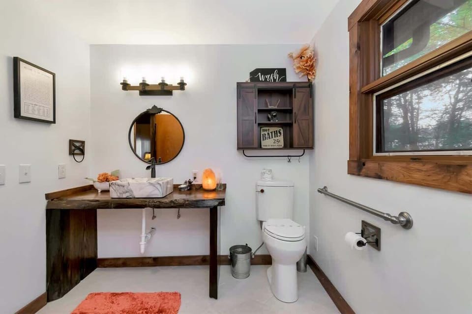 Main level bath with lowered vanity, accessible toilet, grab bars.