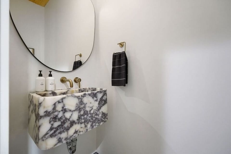 Half Bath: Elegance meets functionality with marble sink and gold accents—perfect for a stylish getaway!