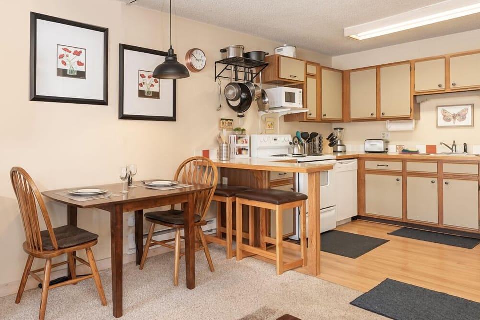 Your fully equipped kitchen awaits with warm wood cabinetry, modern appliances, and a cozy dining nook perfect for morning coffee or home-cooked meals.