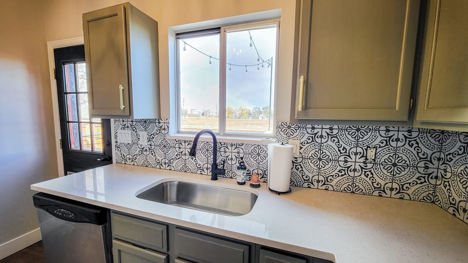 Kitchen window overlooks wildflower field and beautiful backyard