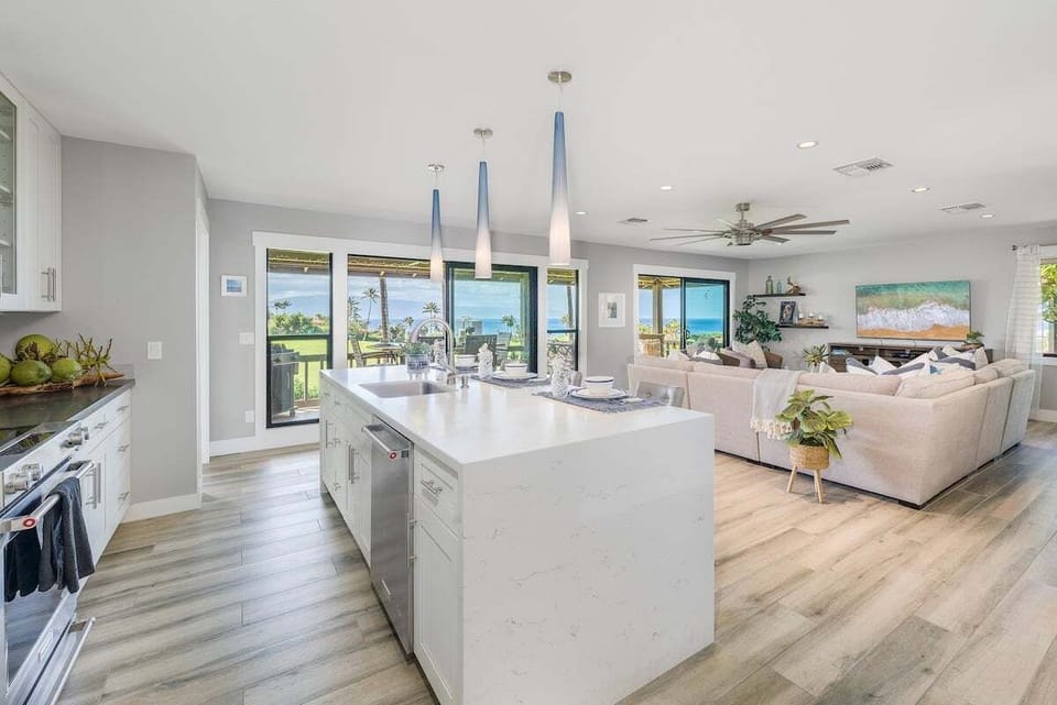 Top quality waterfall style granite countertops and  elegant pendant lights highlight the open concept kitchen