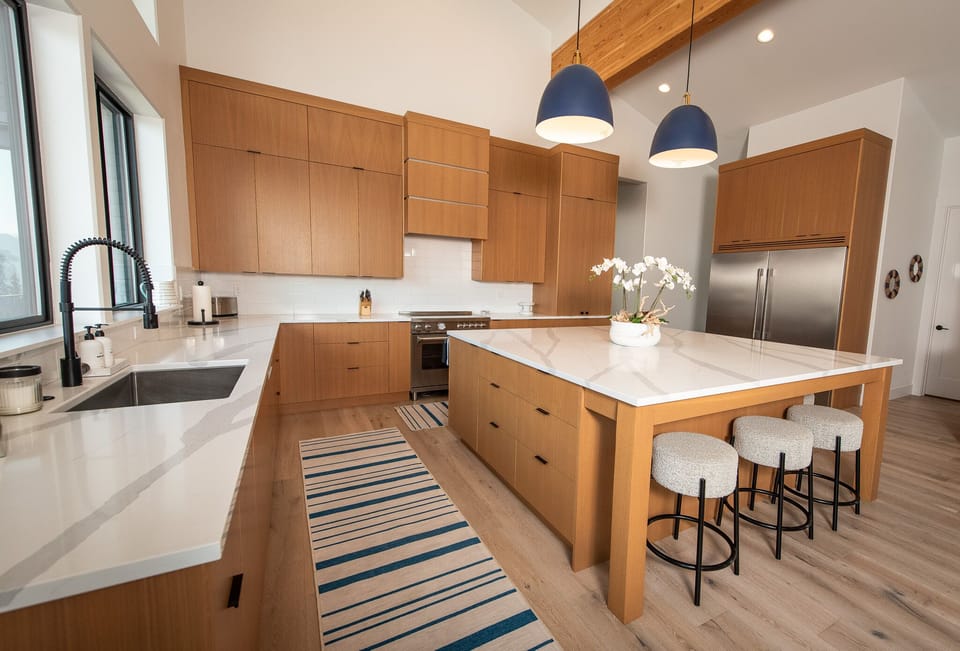 A spacious and well stocked kitchen with large fridge+freezer