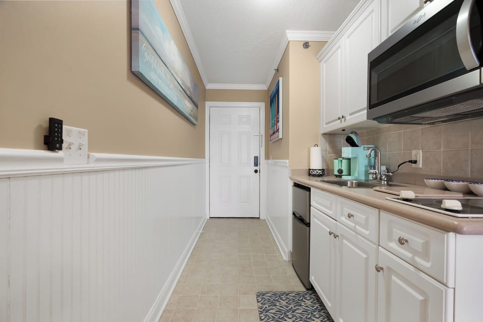 Your fully equipped galley kitchen features white cabinets, stainless appliances, and everything you need for home-cooked meals during your stay.