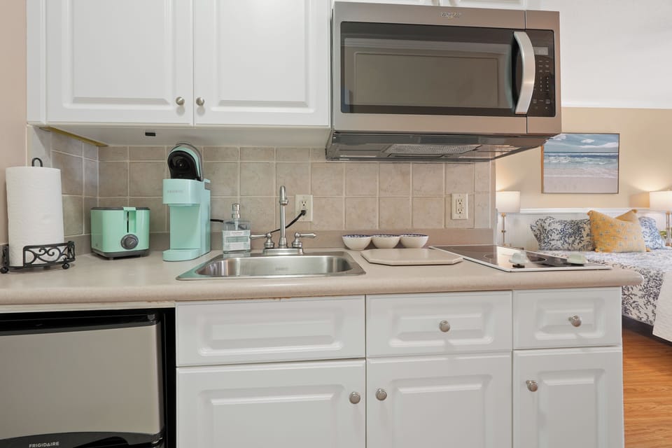 Your fully equipped kitchen makes meal prep a breeze with modern appliances and charming mint-green accents.