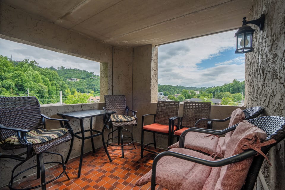 Unwind on your private covered balcony with sweeping views of lush hills and treetops. Comfortable seating invites you to sip morning coffee or enjoy an evening breeze surrounded by natural beauty.