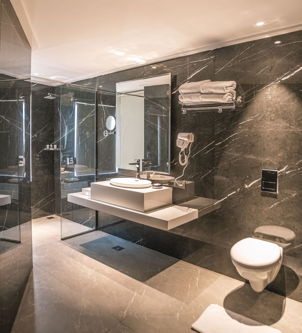Amritara Twin Room | Bathroom | Rainfall showerhead, hair dryer, slippers, towels