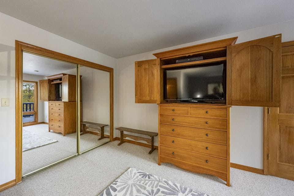 The main bedroom with attached bath and great views from the wall of windows facing the rear deck