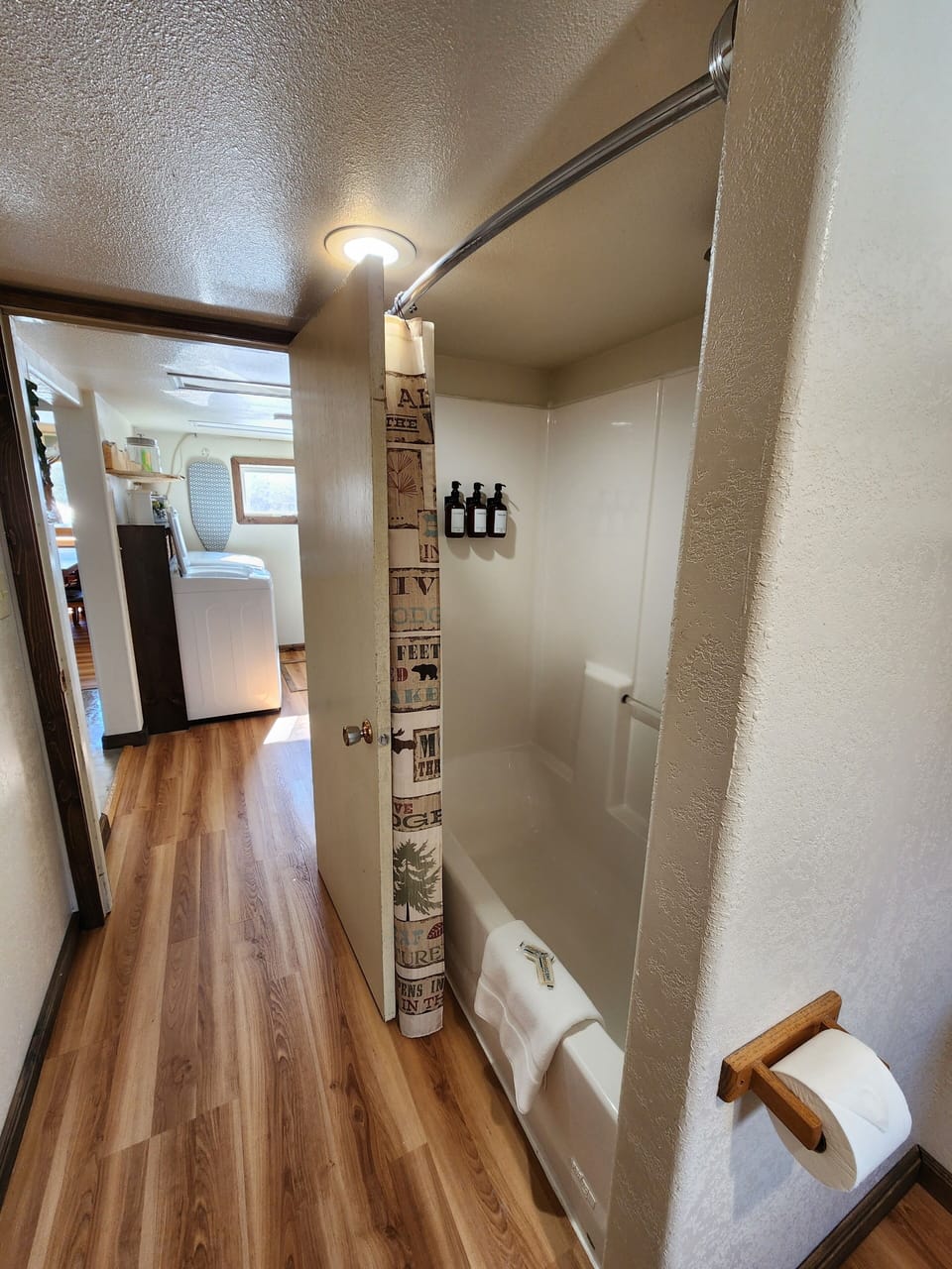 Downstairs full bath with shower. Laundry room seen in the back.