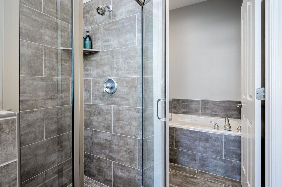 Experience the spacious shower enclosed with a sleek glass door, and separate soaking tub.