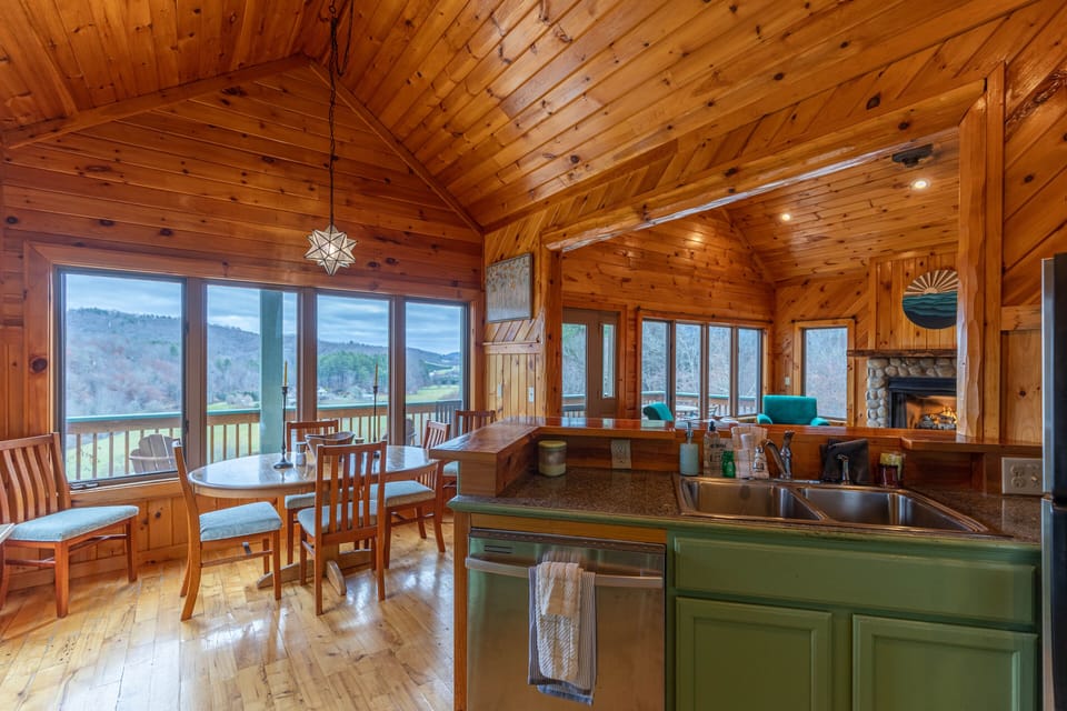 Soaring wood ceilings and wall-to-wall windows frame sweeping mountain views right from the kitchen and dining table.