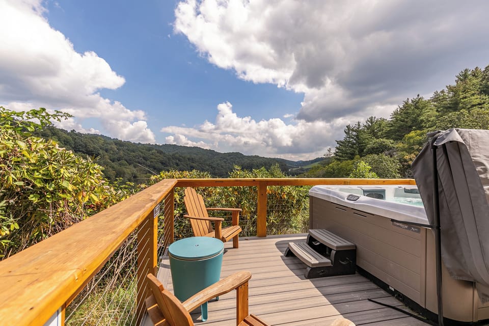 Soak in the hot tub while rolling mountain ridges stretch out before you. Pure Blue Ridge bliss at River View Retreat.