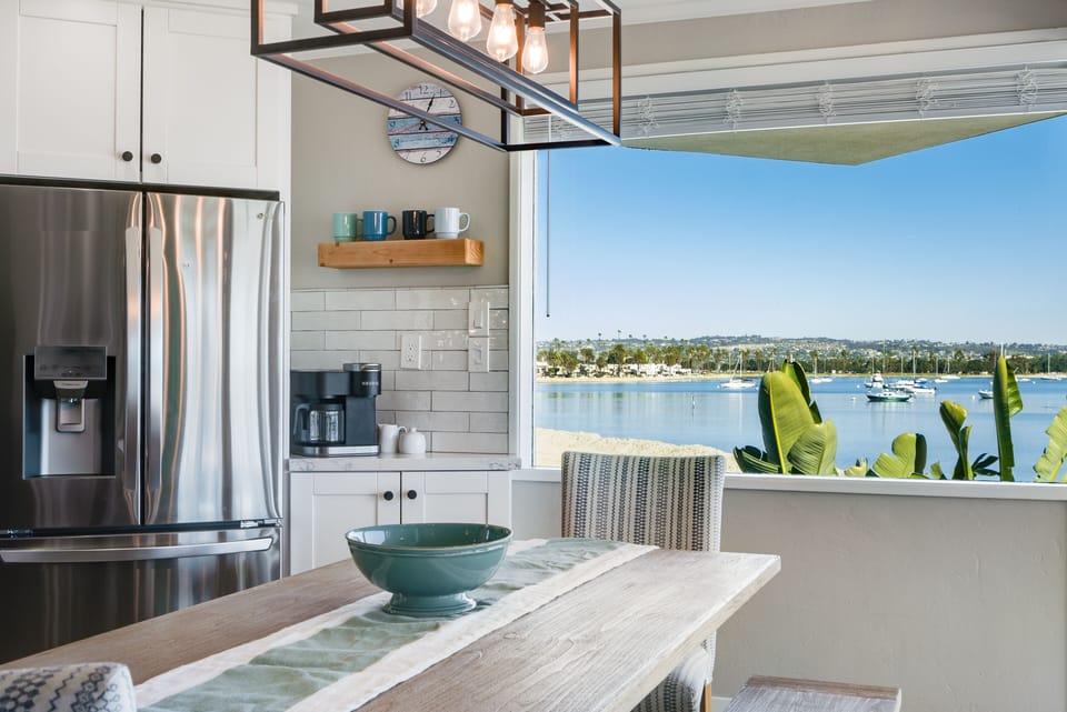 Clear blue tones, wide windows, whites, and soft textiles blend to harmoniously bring the outdoors in.