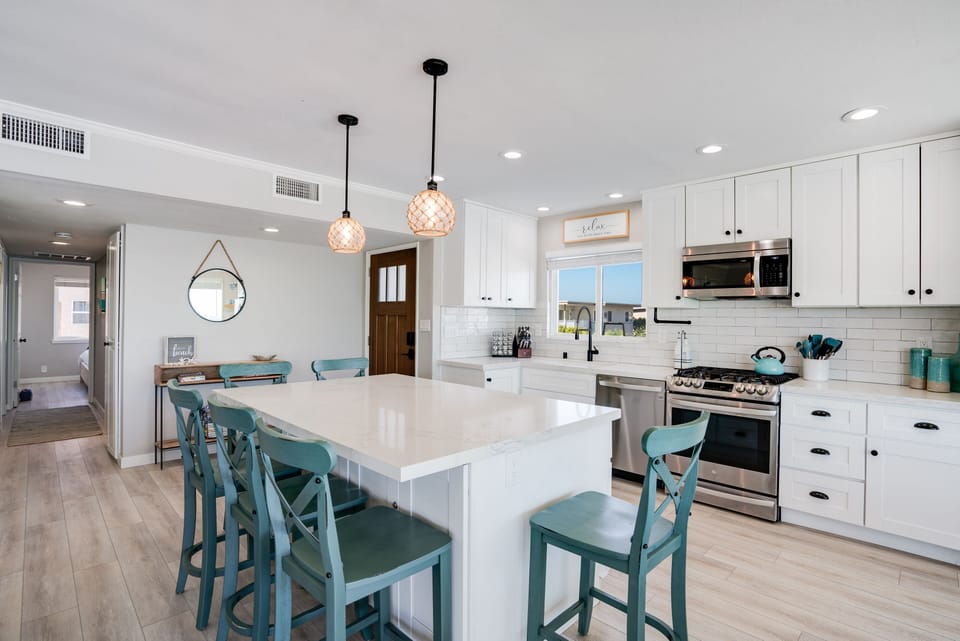 Stylish kitchen with island, fully equipped with high-end appliances, cookware, and tableware.