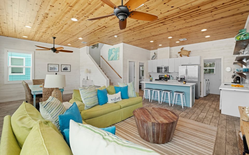 Open Plan Living — Green Sectional, Blue Kitchen Island & Pine Ceiling