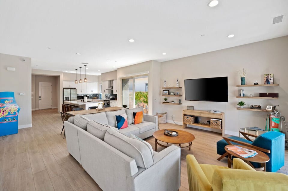 Airy great room w/ modern seating, wall-mounted TV & plenty of natural light.