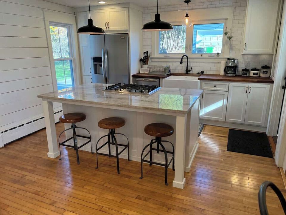 Beautiful kitchen atop wooden flooring and view to private backyard. Easy access from backdoor leads to expansive backyard. 