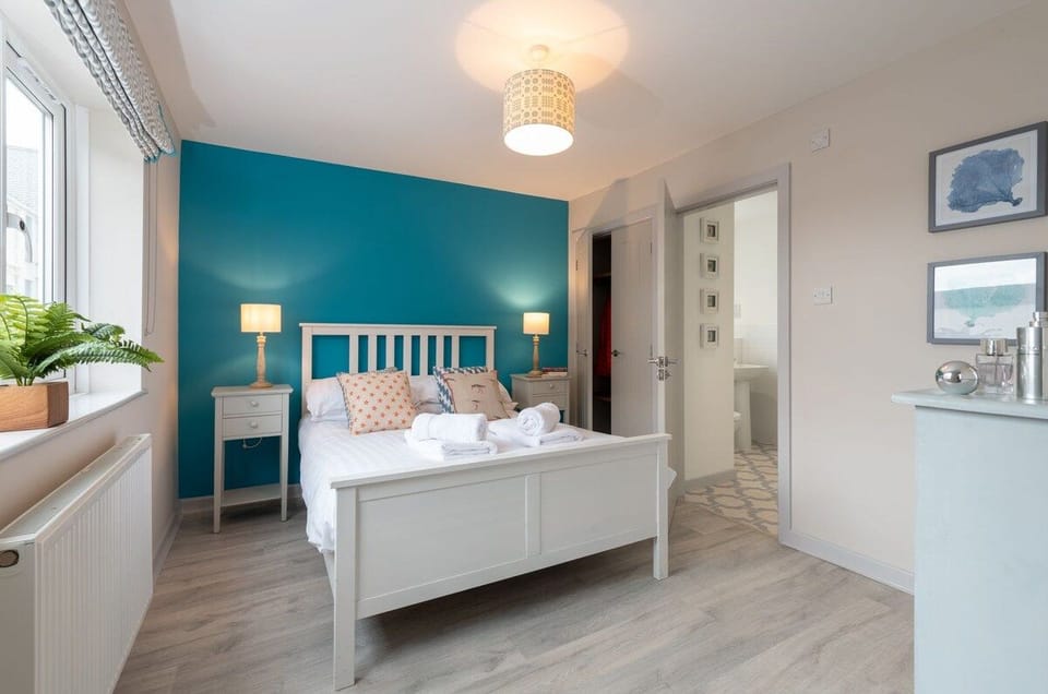 King-sized bedroom with en-suite bathroom, comfortable ground floor accommodation at upside-down cottage in Rhosneigr, Anglesey