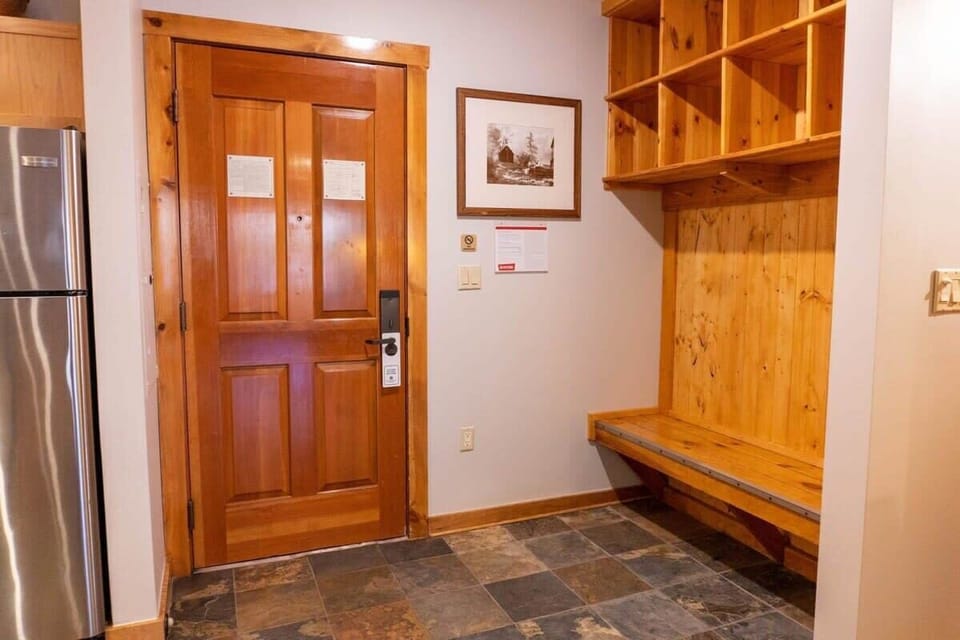 The front hallway of the condo offers a great space to unload your outdoor gear with a built-in wooden bench, coat hangers, and storage cubes.