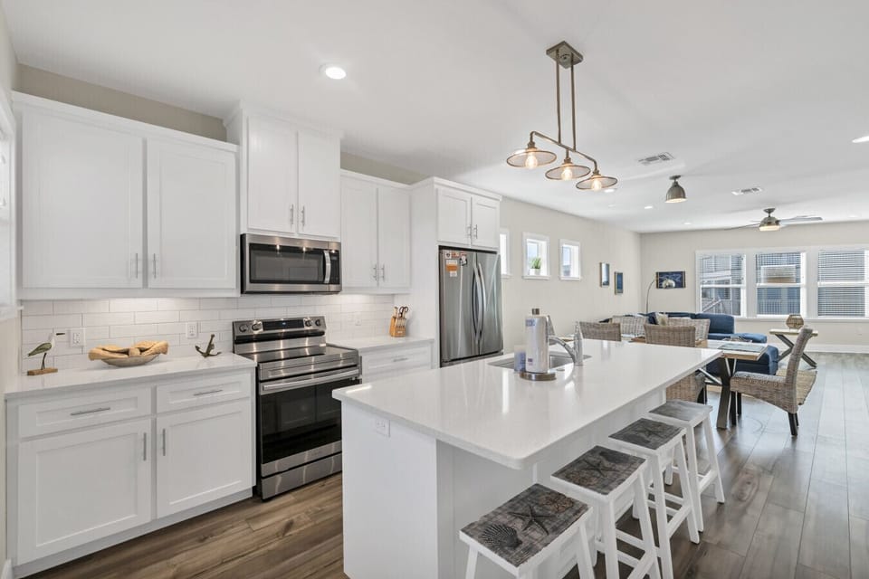 Bright, open coastal kitchen with island seating, modern finishes, and seamless connection to the living area.