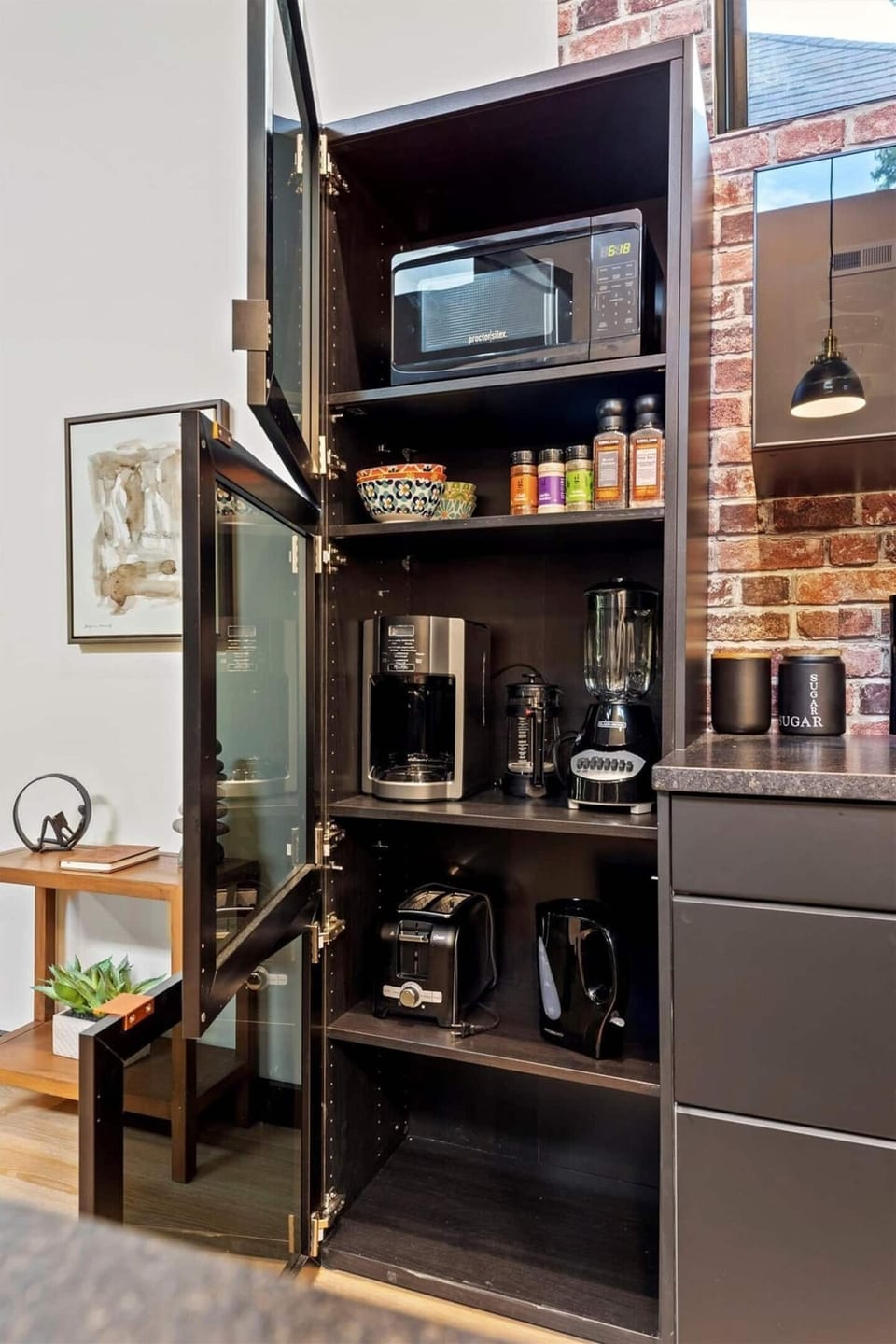 Microwave, coffee pot, basic spices, blender, toaster, hand mixer, etc. in pantry cabinet.